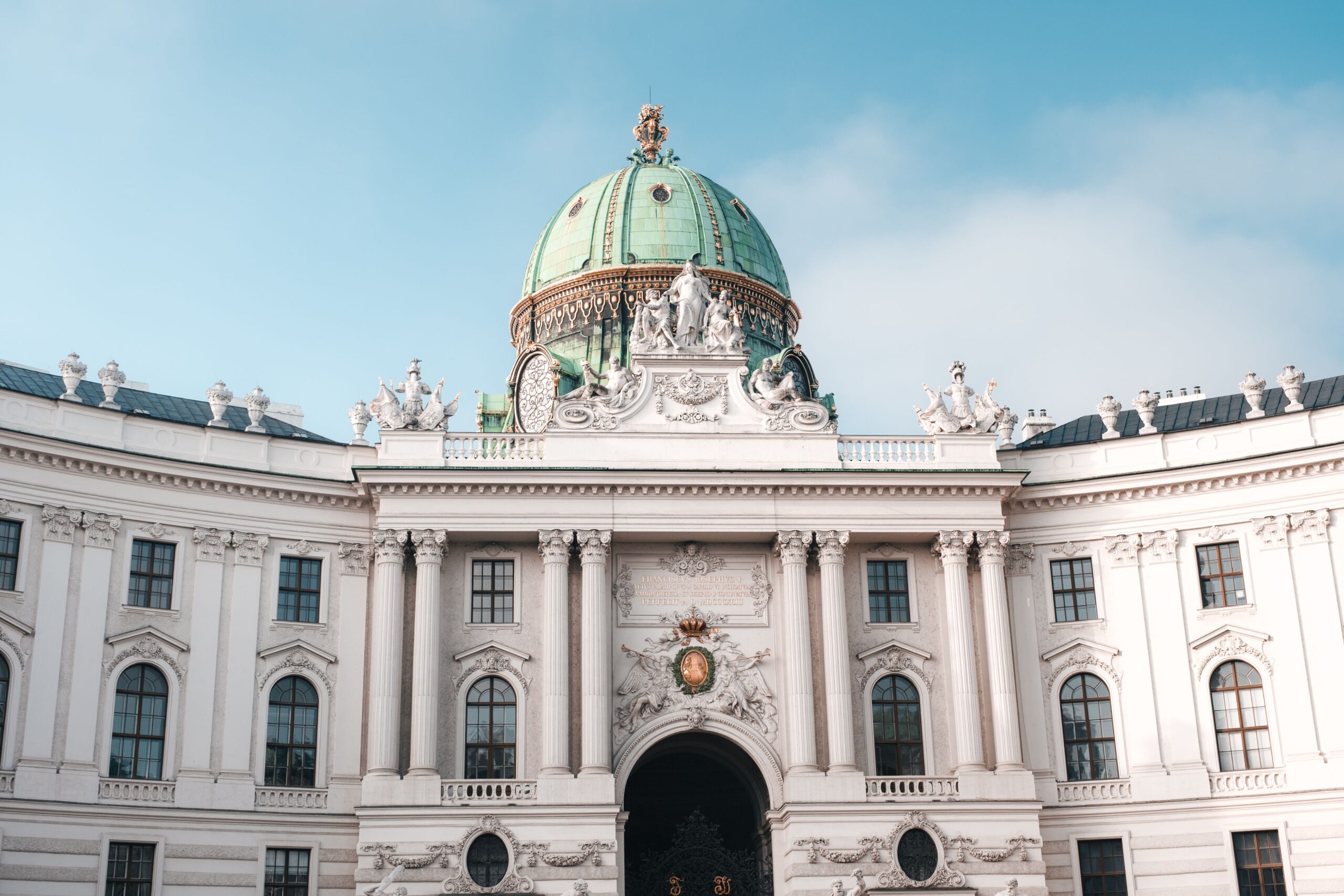 The Hofburg Palace dome and historic facade under a clear sky in Vienna, Austria.